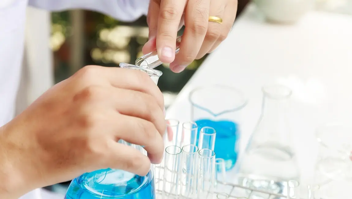 researcher scientists loads liquid sample into beaker laboratory